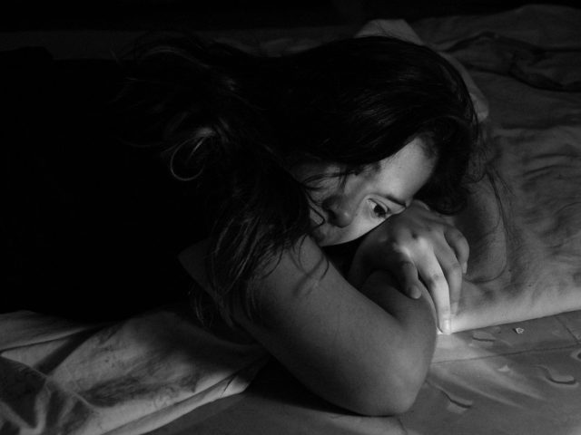 woman leaning on bed